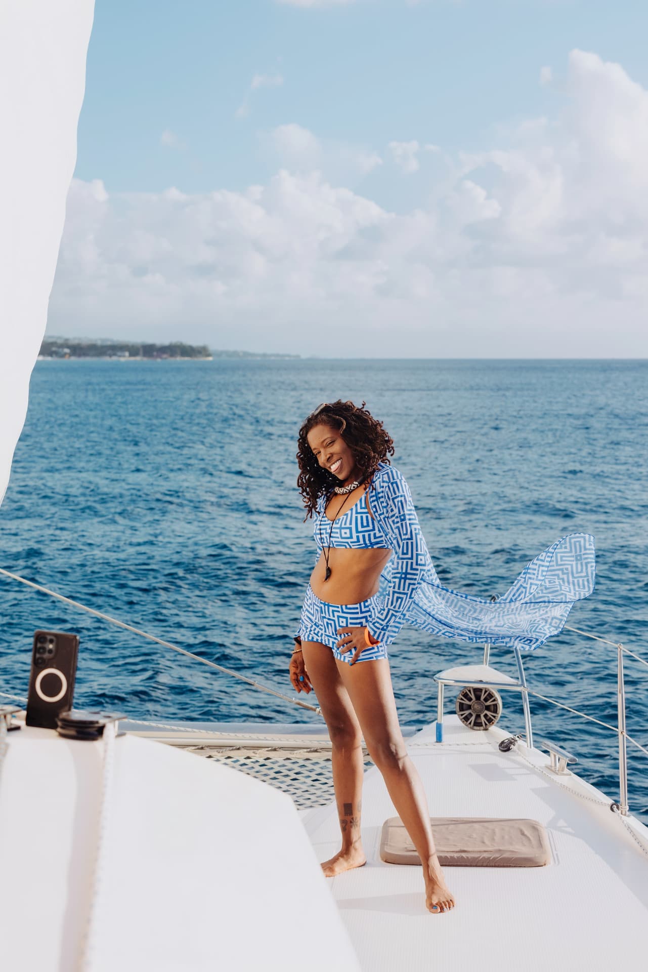 A traveler smiling on the deck of a catamaran off the Barbados coast