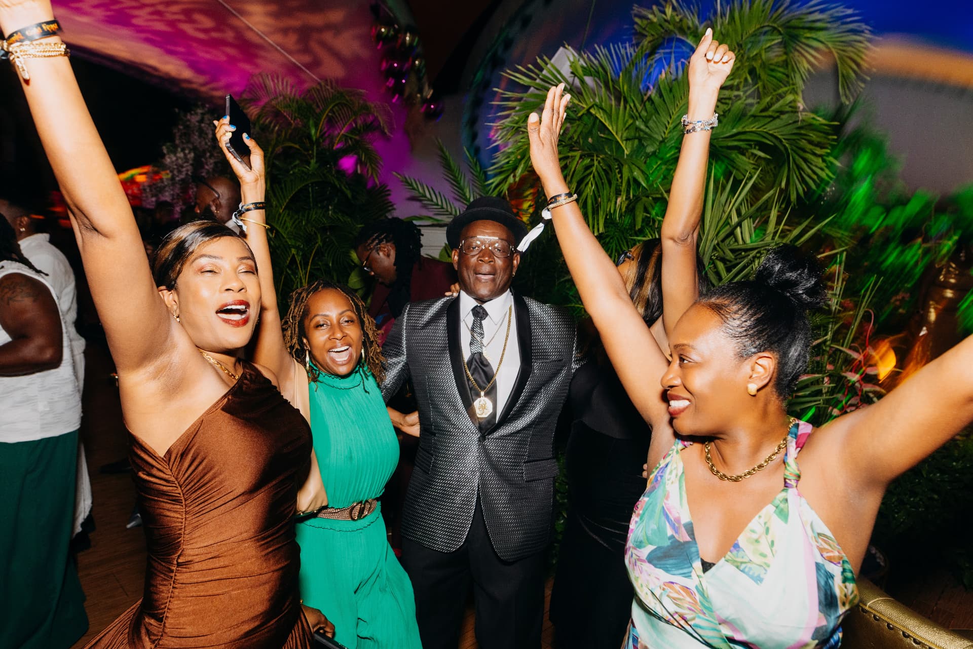 Travelers celebrating with hands raised at an evening festival party