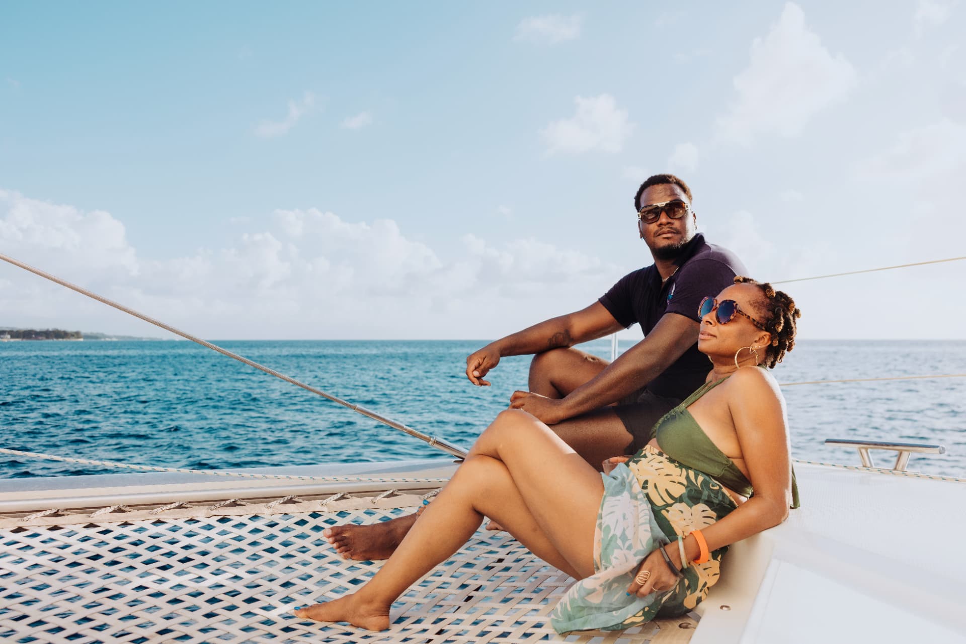 Rufiena Jones and a guest relaxing aboard a catamaran with the Barbados sea behind them