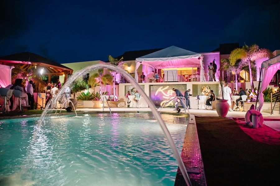 The illuminated pool and fountains at La Maison Michelle during an evening event